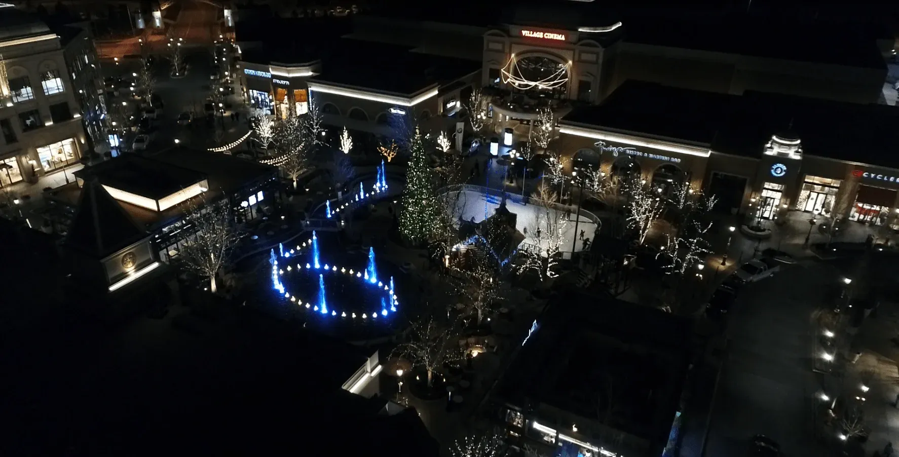 A lit fountain in a Meridian shopping district at night